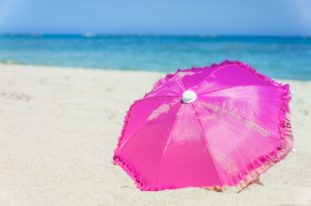 Paraguas de playa rosa bastante vibrante
 - Foto, imagen