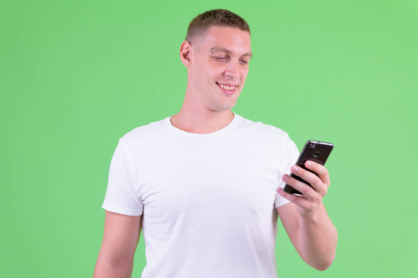 Portret szczęśliwego młodego człowieka za pomocą telefonu - Zdjęcie, obraz