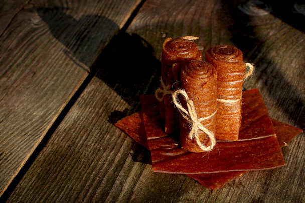 木製の背景に葉のマシュマロが並ぶリネン糸で手作りのアップルパスティーユロール - 写真・画像