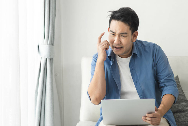 Estressado homem asiático usando laptop em casa, conceito de estilo de vida com
  - Foto, Imagem