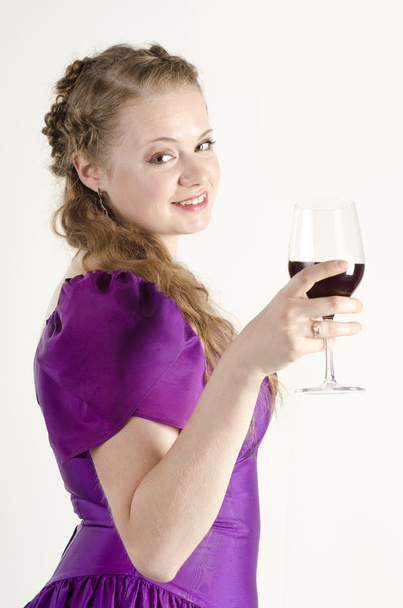Studio portrait of a beautiful, attractive girl with a glass of red wine and dressed like an old fashionable lady on white background - Foto, immagini