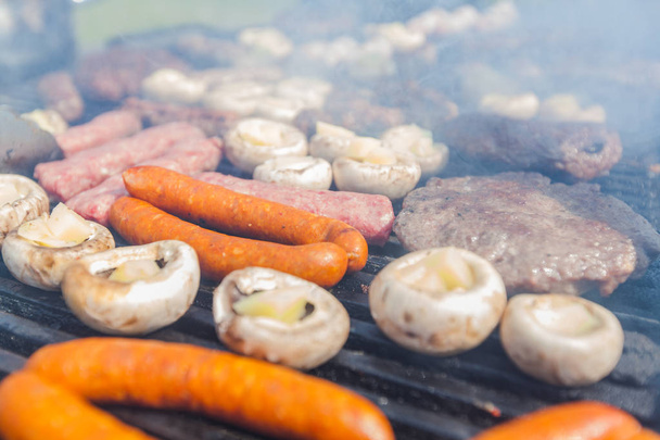Assortment of grilled meat and filled white champignon on barbecue BBQ party  - Photo, Image
