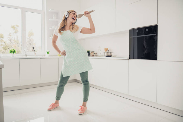 Full length body size view portrait of her she nice attractive lovely cheerful cheery carefree wavy-haired lady having fun singing karaoke in light white interior kitchen - Foto, Bild