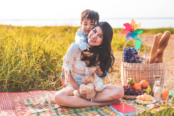 Piękne azjatyckie matka i syn robi piknik i w Wielkanoc lato - Zdjęcie, obraz