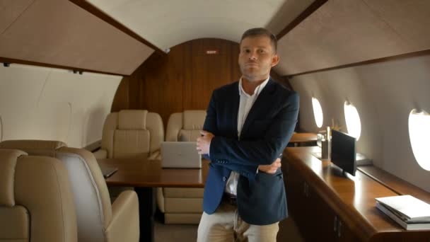 Cheerful confident businessman dancing inside of luxury jet - Video