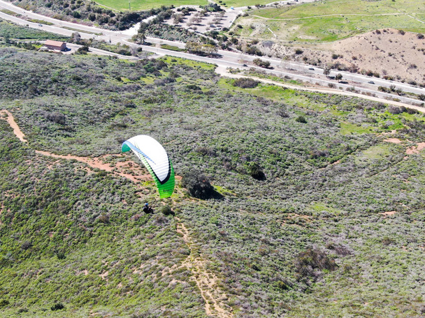 Para-purjelentokone yli vuorten kesällä aurinkoinen päivä. Para-purjelentokone para-plane, strops - huiman lennon hetki lentää yli Black Mountain San Diego, California. Yhdysvallat
.  - Valokuva, kuva