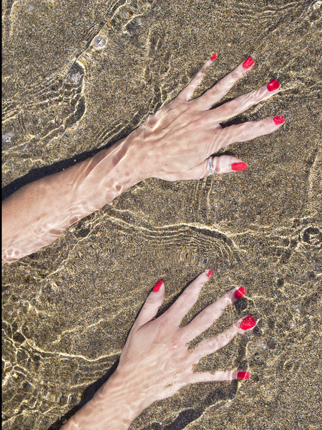 kadın su suların çekildiği kıyı üzerinde siyah kum eller - Fotoğraf, Görsel