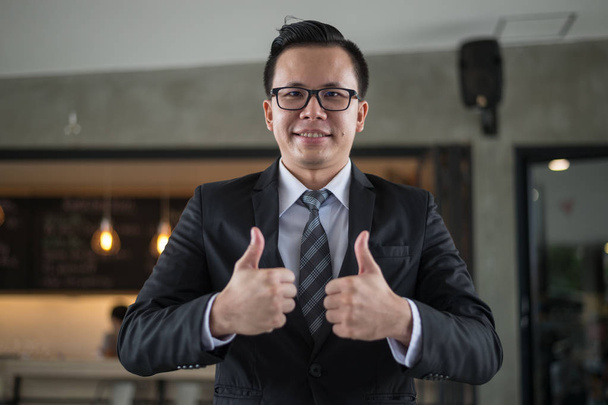 handsome business man smile and show thumb up two hand at the office, successful concept - Foto, Imagen