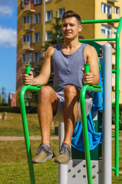 Man doing sit ups in outdoor gym - 写真・画像