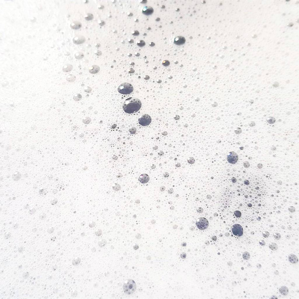 Espuma blanca con burbujas apareciendo de cerca
 - Foto, imagen