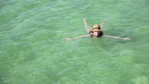 Girl swims in clear colorful transparent water - Filmati, video