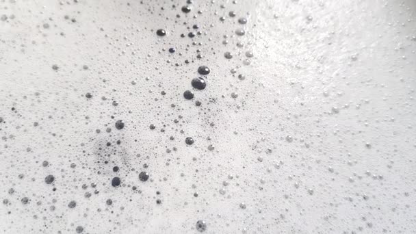 Espuma blanca con burbujas haciendo estallar primer plano
 - Metraje, vídeo
