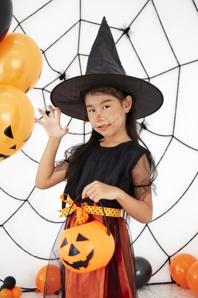 Feliz Halloween pequeña bruja con una calabaza
 - Foto, imagen
