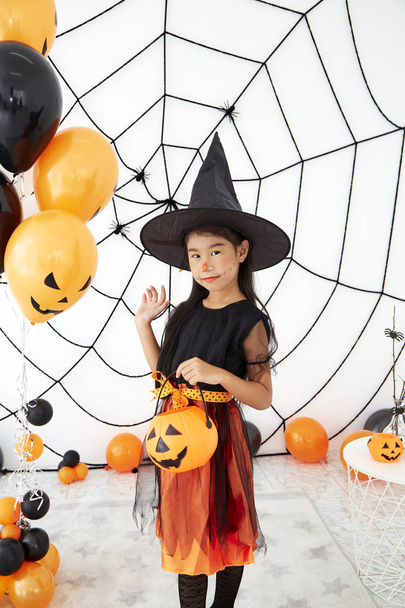 Happy Halloween little witch with a pumpkin - Valokuva, kuva