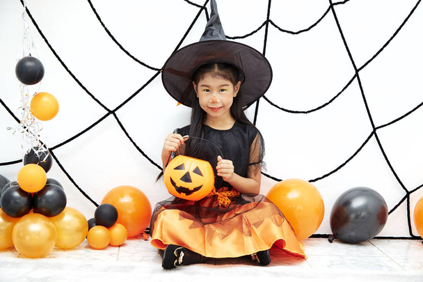 Happy Halloween little witch with a pumpkin - Photo, Image