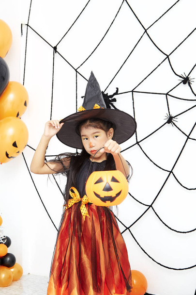Feliz Halloween pequeña bruja con una calabaza
 - Foto, imagen