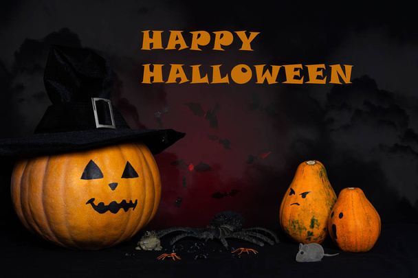 Halloween háttér a betűkkel "Happy Halloween". A sütőtök egy fekete kalap. Sütőtök, egerek, pókok, varangy ellen sötét háttér. - Fotó, kép