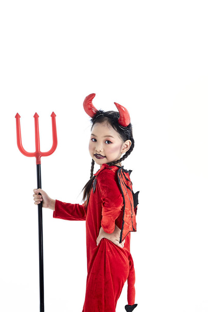 κορίτσι σε ένα αποκριάτικο φανταχτερό φόρεμα διάβολος - Φωτογραφία, εικόνα
