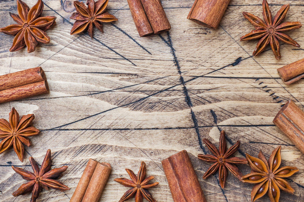Cinnamon sticks and anise stars on wooden background. Copy space. Top view. - Фото, зображення