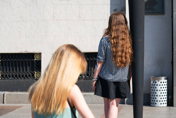 Blonde straight and red curly hair in girls on the street. - 写真・画像