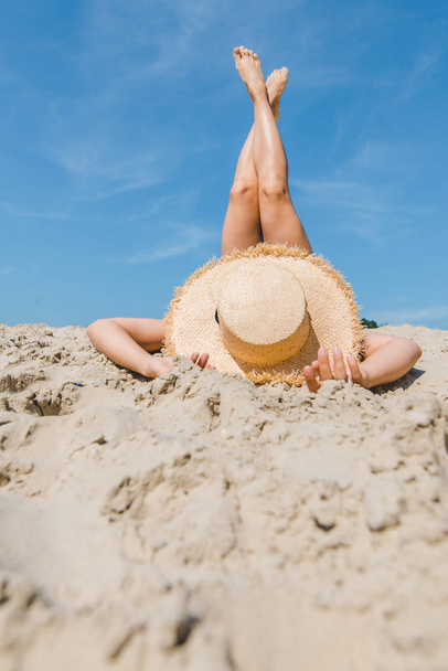 woman laying at sand beach crossing legs up vacation - 写真・画像