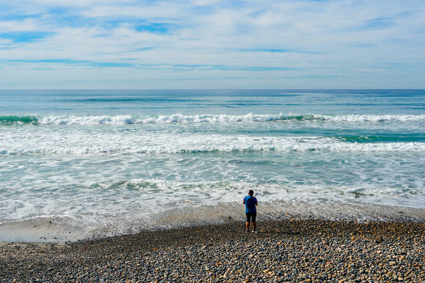 Člověk se baví a prochází pokojným okamžikem na pláži. Torrey piny State Beach v Kalifornii, sídlící v San Diego County. USA.  - Fotografie, Obrázek