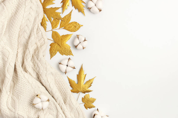 Lakás feküdt őszi kompozíció. Kötött gyapjú világos bézs pulóver vagy kockás, arany száraz levelek, pamut virágok fehér háttérrel felülnézetben másolás helyet. Ősz, bukása koncepció - Fotó, kép