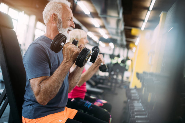 Happy mature people doing exercises in gym to stay fit - Photo, Image