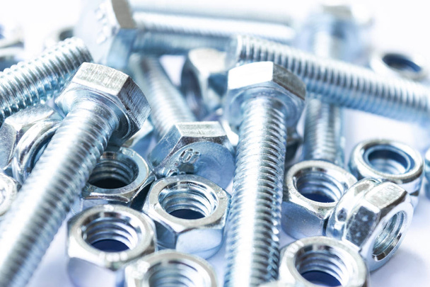 Metal bolts and nuts  in a row background. Chromed screw bolts and nuts isolated. Steel bolts and nuts pattern. Set of Nuts and bolts. Tools for work.  - 写真・画像