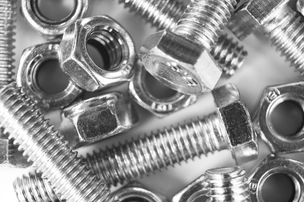 Metal bolts and nuts  in a row background. Chromed screw bolts and nuts isolated. Steel bolts and nuts pattern. Set of Nuts and bolts. Tools for work. Black and white - Foto, imagen