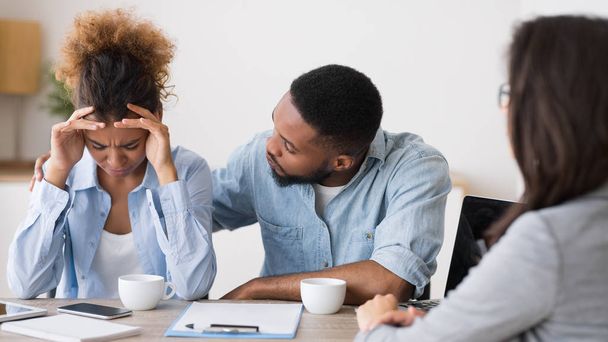 Zwarte man Trooting huilen vrouw op finansial counseling - Foto, afbeelding