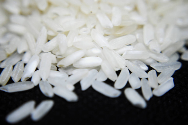 Une poignée de riz blanc (basmati) sur fond noir
  - Photo, image