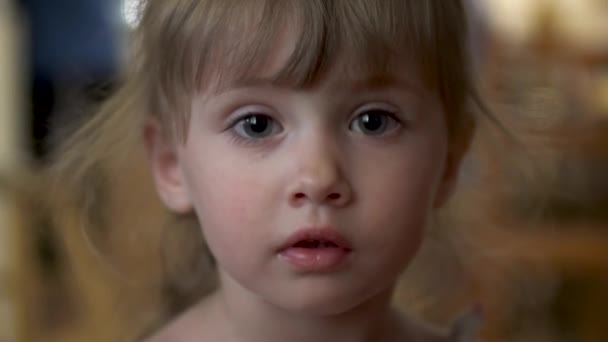 Little girl looks at the camera close-up - Footage, Video