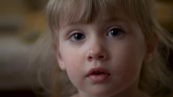 Маленькая девочка смотрит в камеру крупным планом - Кадры, видео