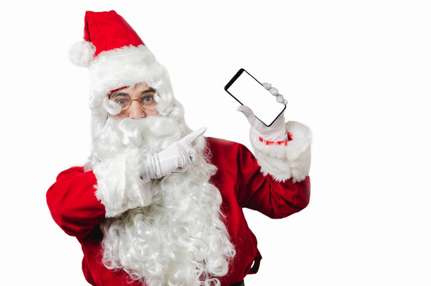 Ο Άγιος Βασίλης δείχνοντας έξυπνο τηλέφωνο σε λευκό μαύρο με αντίγραφο  - Φωτογραφία, εικόνα