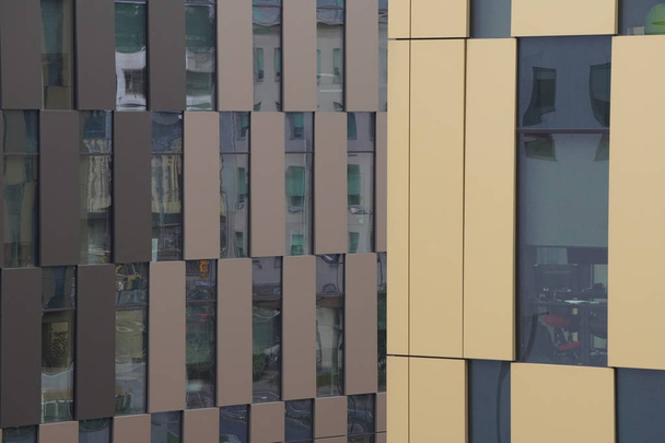 коричневый фасад современного здания, офиса или жилого здания. Красный кирпич, много стекла, небоскреб. Окна разных размеров
 - Фото, изображение