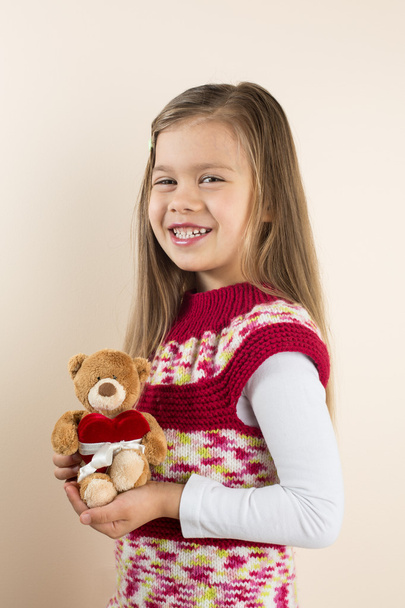 Young Girl Holding Teddy Bear with Toy Heart - Fotó, kép