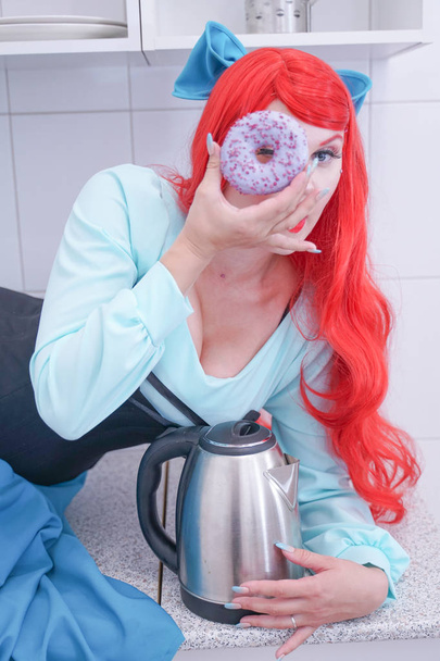 Hungry attractive girl eating donut on the kitchen - Photo, Image