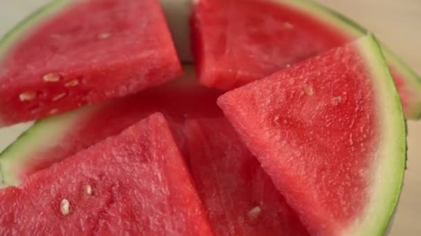 Gesneden watermeloen draait op een houten oppervlak. De smaak van de frisse zomer. Dorstige traktatie - Video