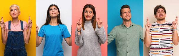 Set of people over colorful backgrounds with fingers crossing and wishing the best - Photo, Image