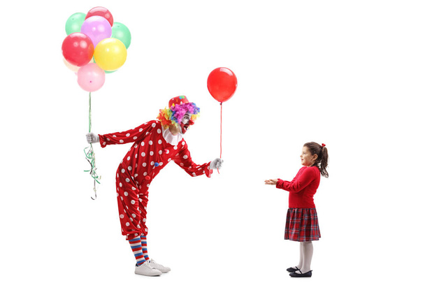 Clown giving a balloon to a little girl and holding a bunch of b - Fotografie, Obrázek