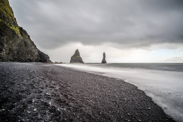 Zwarte zandstrand en rotsformaties "Troll tenen". Reynisdrangar, Vik, IJsland - Foto, afbeelding
