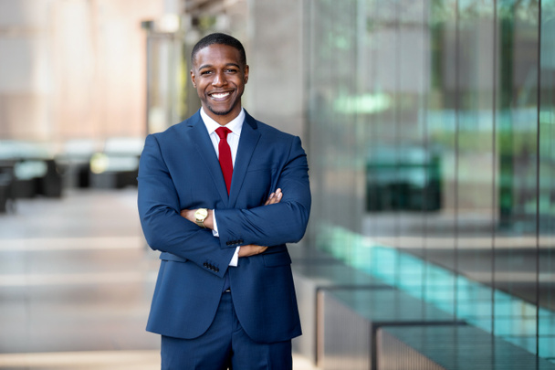 Modern African American CEO portrait standing confidently, with arms crossed, at swanky luxurious office building - Photo, Image