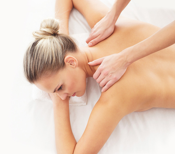 Young attractive woman getting massaging treatment over white ba - Fotografie, Obrázek