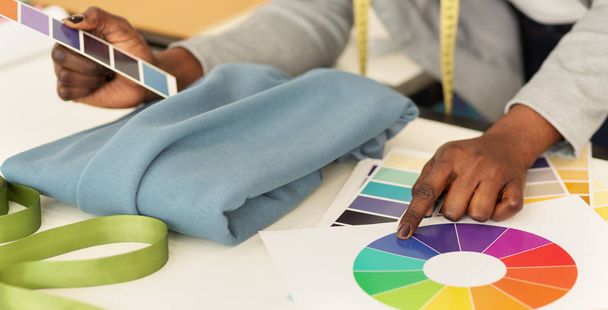 Γυναικεία σχεδιαστής εργασίας με ύφασμα και δείγματα χρωμάτων, κοντινά πλάνα - Φωτογραφία, εικόνα