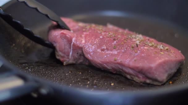 frying beef steak in a pan - Filmati, video
