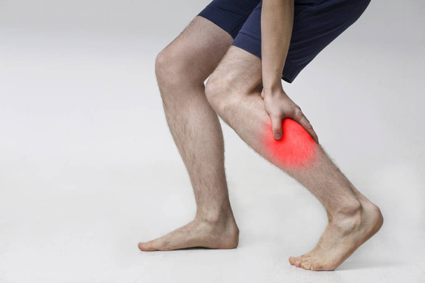 Yaralı baldırlı adam, ağrılı bacak kası masaj - Fotoğraf, Görsel