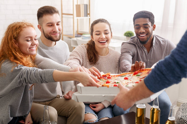 Felices amigos tomando rebanadas de pizza caliente de la caja
 - Foto, Imagen