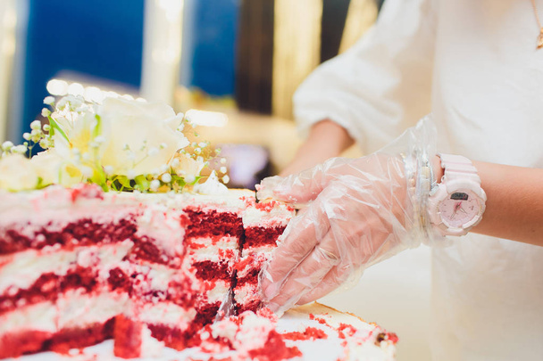 Триярусний білий весільний торт, прикрашений квітами з мастики на білому дерев'яному столі. Зображення для меню або каталогу кондитерських виробів з копіювальним простором
. - Фото, зображення