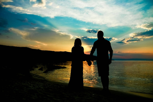 szczęśliwa para sylwetka przez greckie morze na tle brzegu - Zdjęcie, obraz